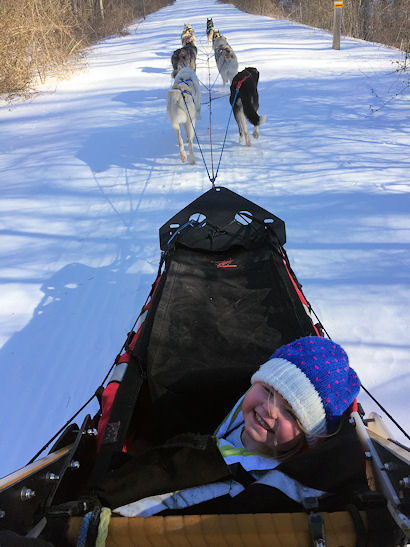 One of the participants at the Maine Winter Cabin Adventure tries her hand at driving the team
